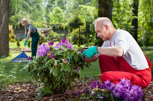 Career gardener training session demonstrating PPE and safe tool handling